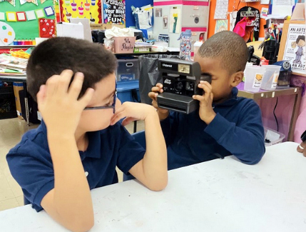 School children, grade 1, take pictures with a Polaroid camera