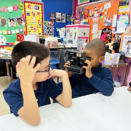 School children, grade 1, take pictures with a Polaroid camera